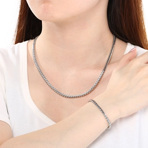 Detail of silver stainless steel woven chain necklace and bracelet set on a model