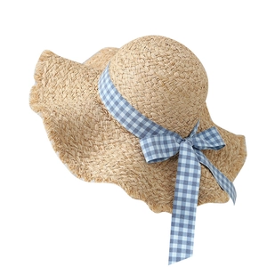 Raffia sun hat with wide frayed brim and blue checkered bow ribbon for beach vacation
