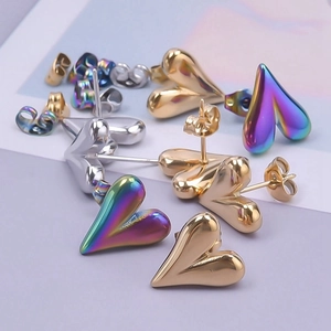 Macro shot of heart-shaped stainless steel earrings in gold, silver, and rainbow finishes