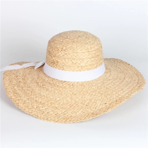 Straw sun hat with wide brim and white ribbon bow for beach vacations and summer sun protection
