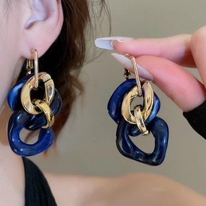 Close-up of vintage blue marble resin and gold chain links on statement earrings