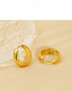 Detailed view of chunky 18K gold plated hoop earrings on elegant silk fabric
