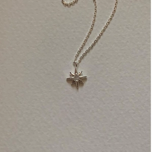 Elegant 925 sterling silver starburst pendant necklace with a zircon stone on white background