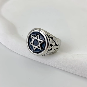 Close-up van roestvrijstalen ring met zwart emaille hexagram en gedetailleerde adelaarskop zijkant