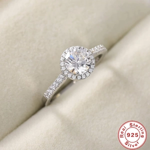 Macro shot of halo silver ring with large center diamond in beige velvet jewelry box