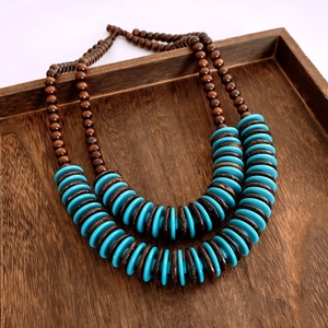 Dettaglio di collana etnica a due strati con perle di legno scuro e dischi blu