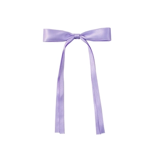 Detailed view of a purple silk ribbon bow hair clip with elegant long streamers