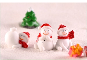Macro view of 3 resin snowmen with miniature Christmas tree and red gift box set