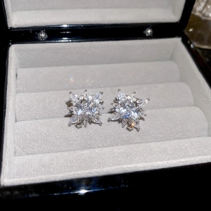 Macro shot of sparkling star-shaped zircon stud earrings presented in a luxury jewelry box