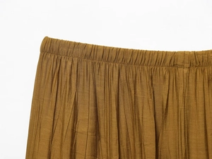 Detail of the elastic waistband on mustard yellow pleated midi skirt with crinkle texture