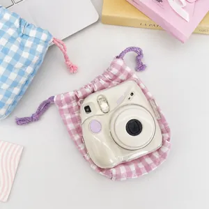 Detail van gewatteerde geruite tassen met trekkoord in paars en blauw voor camera's