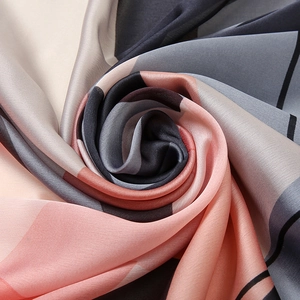 Modern geometric print silk scarf in pink and grey with soft glossy texture and drape
