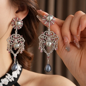 Gros plan de boucles d'oreilles vintage avec perles bleues et cristaux roses sur argent