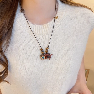 Artistic resin cat and camera pendant necklace with blue gem on a woven cord