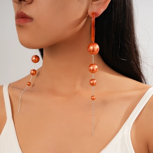 Model wearing vintage oval acrylic pearl drop earrings with long silver chain tassels