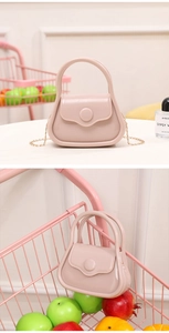 Close-up of pink mini jelly bag with glossy finish and gold metal chain strap