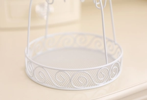 Detail of white wrought iron jewelry tray featuring elegant hollow spiral patterns