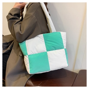 Detail view of large quilted puffer tote bag featuring green and white checkerboard pattern