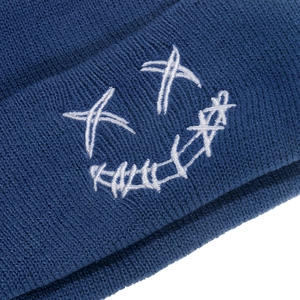 Detailed view of the dark blue ribbed knit beanie featuring white face embroidery