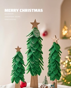Detailed view of three tiered felt Christmas trees with wood bases and snowy edges