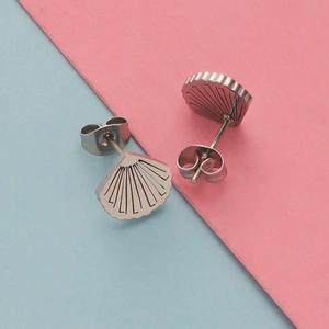 Minimalist stainless steel seashell stud earrings on a pink and blue background