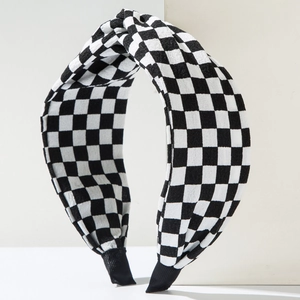 Detail shot of black and white checkerboard headband with stylish top knot design
