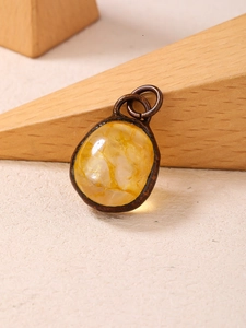Macro detail of natural citrine pendant with vintage bronze frame on wooden prop