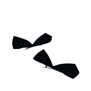 Pair of chic black velvet bow hair clips for women on a minimalist white background