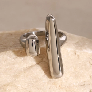Macro shot of silver polished geometric open ring displayed on a natural stone background