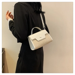 Vue détaillée du sac en similicuir blanc et tissu tressé porté par un mannequin