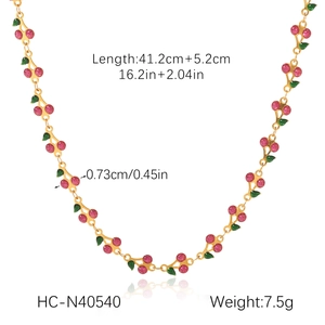 Flat lay of gold cherry necklace with pink glitter pendant showing length and weight specs