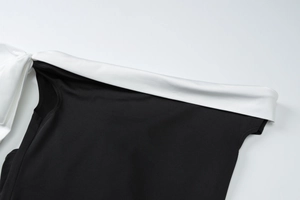 Detail of elegant black and white contrast dress showing off-shoulder ribbon knot design