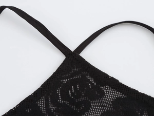 Close-up of the delicate lace fabric and thin straps on a sexy black halter dress