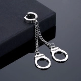 Detail of silver stainless steel drop earrings featuring mini handcuffs and Freedom engraving