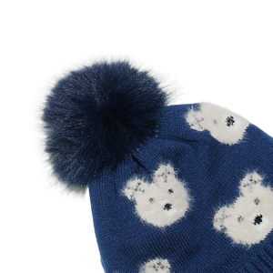 Detail der dunkelblauen Strickmütze mit weißem Bärenmuster und großem Kunstfell-Bommel