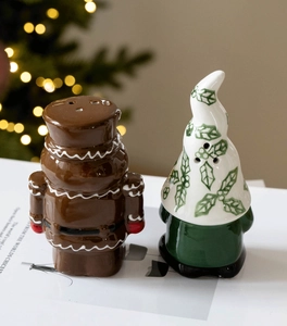 Close-up of ceramic gingerbread man and gnome salt and pepper shakers on holiday table