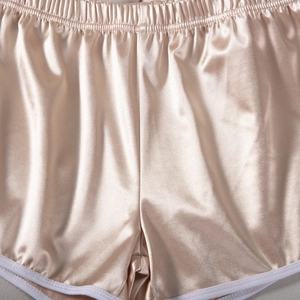 Detail of champagne satin sports shorts featuring elastic waistband and white trim
