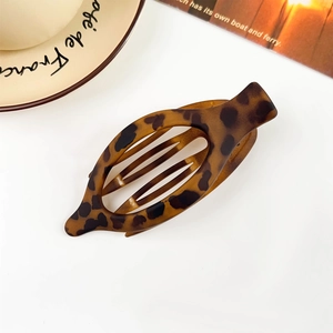 Detail view of large oval matte leopard print hair claw clip on a white background