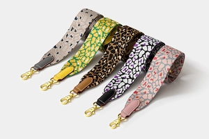 Five leopard print woven wide shoulder straps with leather ends and gold metal hooks