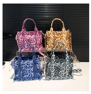 Detailed view of four colorful leopard print canvas tote bags on a display stand