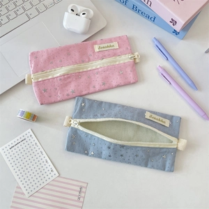 Close-up of pink and blue canvas pencil cases with silver stars and sturdy zippers