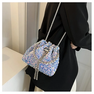 Detail of light blue sequined bucket bag with silver metal ring handle and chain strap
