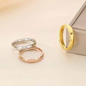 Three minimalist polished 4mm stainless steel rings in silver, gold, and rose gold finishes