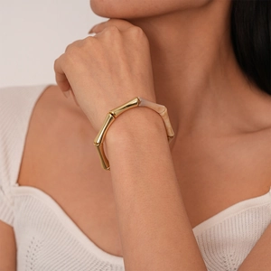 Gros plan du bracelet style bambou avec segments en métal doré et résine marbrée crème
