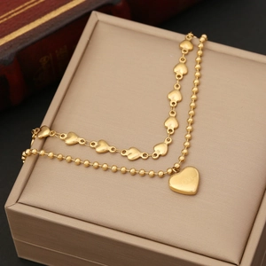 Gold double-layered necklace featuring heart links and heart pendant with LOVE engraving