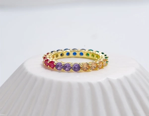 Detail of eternity rainbow ring with colorful zircon stones in gold prong setting
