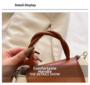 Detailed macro shot of the twisted round handle on a brown and white contrast handbag