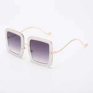 Fashion square sunglasses with transparent glitter frames and golden wavy metal temples