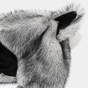 Close-up of fluffy faux fur fox ears with grey and black texture on a winter hat