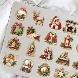 Detailed arrangement of vintage Christmas stickers with Santa and reindeer on a laptop surface